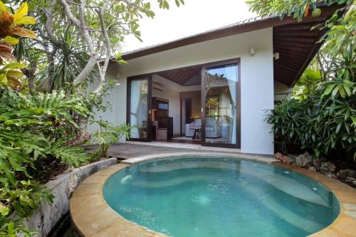 a swimming pool in front of a villa at Karang Saujana in Uluwatu