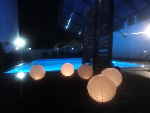 a group of paper lanterns in front of a pool at night at Blue Spring Hotel Wadduwa in Wadduwa