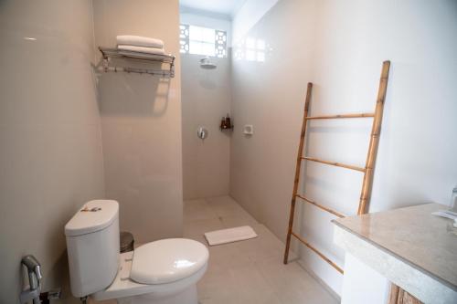 a bathroom with a white toilet and a shower at The Eight Villa & Rooms Bali - Seminyak in Seminyak
