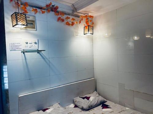 eine Ecke eines Badezimmers mit geschwungener Wand und zwei Leuchten in der Unterkunft Den near the sea in Mumbai