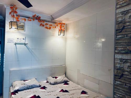 ein Zimmer mit einem Bett in der Zimmerecke in der Unterkunft Den near the sea in Mumbai