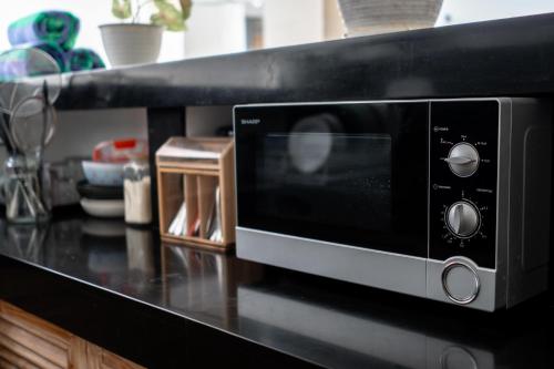 a microwave oven on a counter in a kitchen at The Eight Villa & Rooms Bali - Seminyak in Seminyak