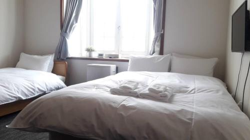 a bedroom with two white towels on a bed at Sunshine Hakuba Ski-to-door by JAMSZ ROYALE in Hakuba
