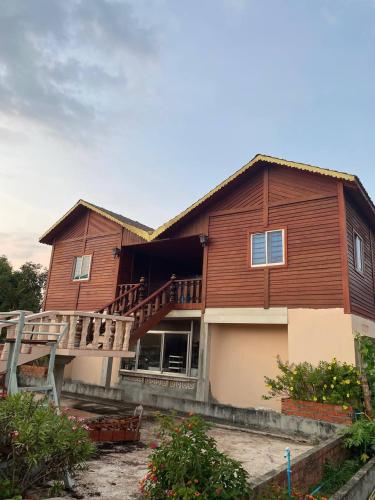 a large wooden house with a porch and a balcony at The new camping Mangrove in Phumĭ Chroŭy Svay