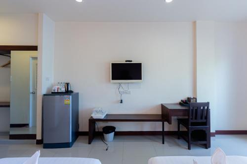 a room with a desk and a tv on a wall at Panwalee Hotel in Khon Kaen