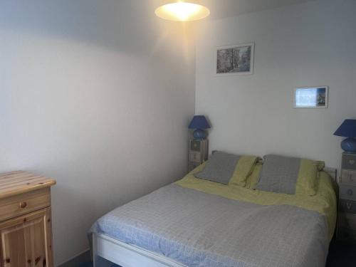 une chambre avec un lit avec deux oreillers dessus dans l'établissement T2 à Cauterets avec alcôve, proche parking - FR-1-812-119, à Cauterets