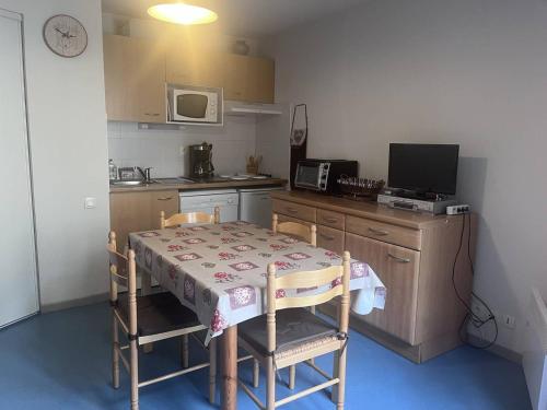 une cuisine avec une table et des chaises ainsi qu'une cuisine avec une table et une table dans l'établissement T2 à Cauterets avec alcôve, proche parking - FR-1-812-119, à Cauterets