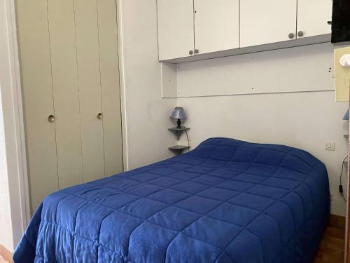 - une chambre avec un lit bleu et des armoires blanches dans l'établissement Appartement T1 lumineux avec balcon et vue sur étang à Balaruc-les-Bains - FR-1-553-295, à Balaruc-les-Bains