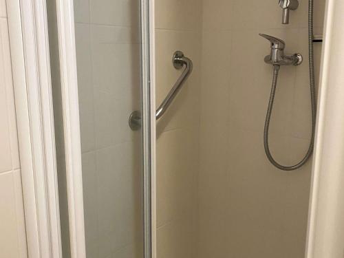 une douche dans une salle de bain avec une porte vitrée dans l'établissement Appartement T1 lumineux avec balcon et vue sur étang à Balaruc-les-Bains - FR-1-553-295, à Balaruc-les-Bains