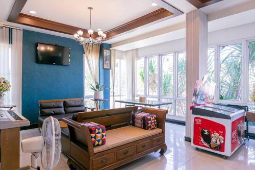 a living room with a couch and a video game at Panwalee Hotel in Khon Kaen