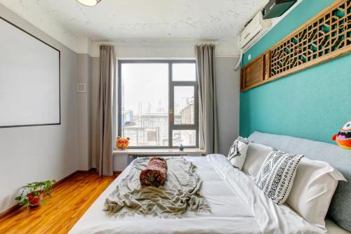 a bedroom with a bed and a large window at Cloth Tiger Inn in Taiyuan