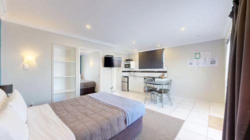 a hotel room with a bed and a kitchen at Albatross Motel in Napier