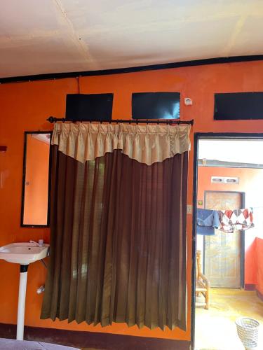 a bed with a curtain in a room at ROY HOMESTAY KUTA in Kuta Lombok