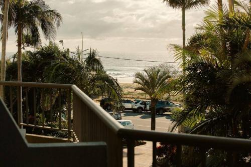 a balcony with a view of a parking lot with palm trees at The Rocks Resort Unit 2i in Gold Coast