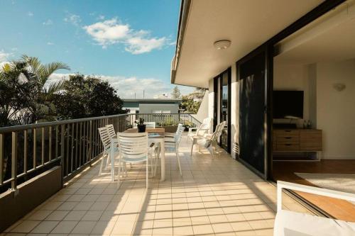 a balcony with chairs and a table and a television at The Rocks Resort Unit 2i in Gold Coast