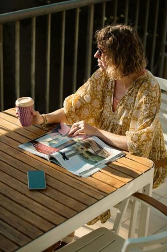 a woman sitting at a table reading a magazine at The Rocks Resort Unit 2i in Gold Coast