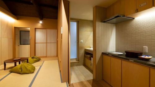 a kitchen with a counter and a table in a room at 壬生宿 MIBU-JUKU Shichijo-Umekoji in Kyoto
