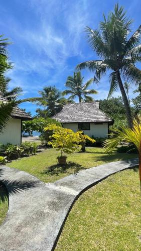 a path leading to a house with palm trees at Punatea Village in Afaahiti
