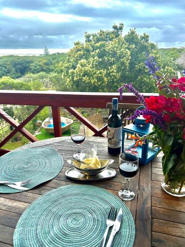 a table with glasses of wine and a bowl of food at Hemel in Hermanus Three bedroom Home in Hermanus