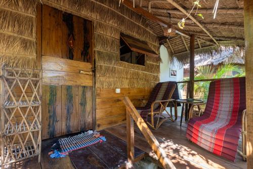 a cabin with a bed and a table and chairs at Kampot Cabana in Kampot