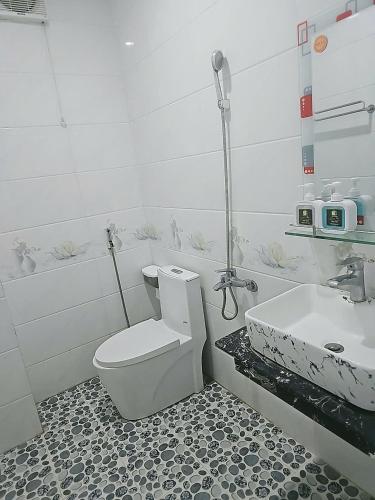 a bathroom with a toilet and a sink at Nhà Khách Hoàng Thắng in Bồng Sơn