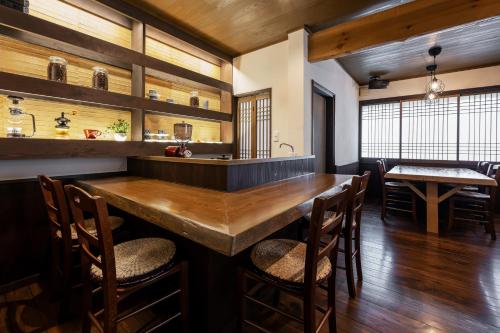 a dining room with a large wooden table and chairs at うり房旅館 in Kusatsu