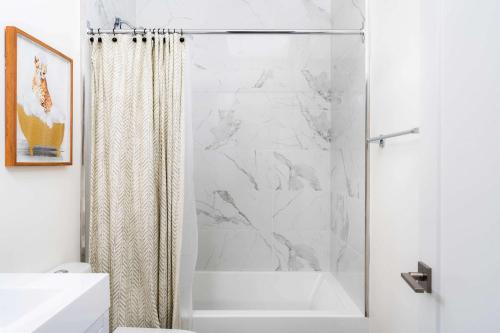 a bathroom with a shower curtain and a tub at Large Victorian Sleeps 6 by UofT in Toronto
