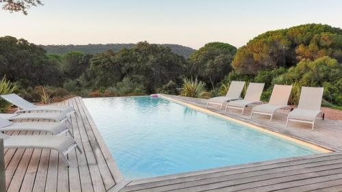- une piscine avec des chaises longues à côté d'une terrasse dans l'établissement Appartement spacieux à Porto-Vecchio avec piscine partagéeB, à Porto-Vecchio