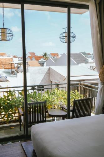 a bedroom with a bed and a large window at Hoi An Ti Hon House in Hoi An