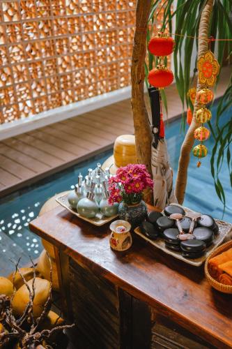 a tray of food on a table next to a pool at Hoi An Ti Hon House in Hoi An