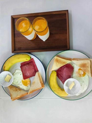 dos platos de desayuno con huevos y tostadas en East Holiday Resort Moalboal, en Moalboal