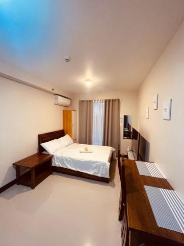 a bedroom with a bed and a desk and a television at Jack Cabin in Lapu Lapu City