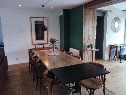 une salle à manger avec une table et des chaises en bois dans l'établissement confortable maison familiale à l'entrée du village médiéval, à Noyers-sur-Serein