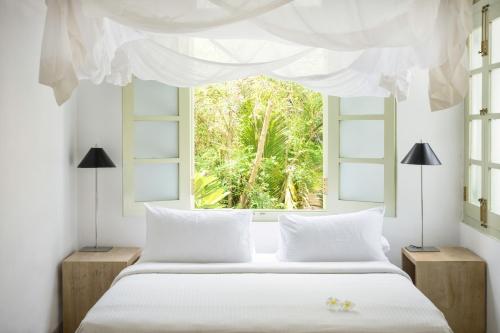 a bedroom with a white bed and a window at The Fort Printers in Galle