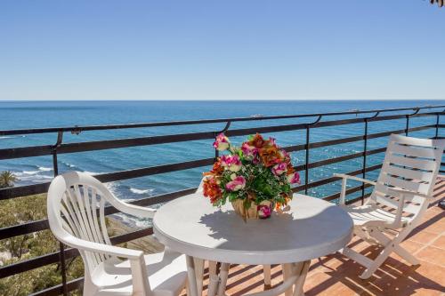 einen Tisch mit einem Blumenstrauß auf dem Balkon in der Unterkunft Apartamento Mediterraneo Side in Marbella
