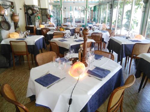 jadalnia z białymi stołami i krzesłami w obiekcie Ristorante Hotel Mira w mieście Sestri Levante