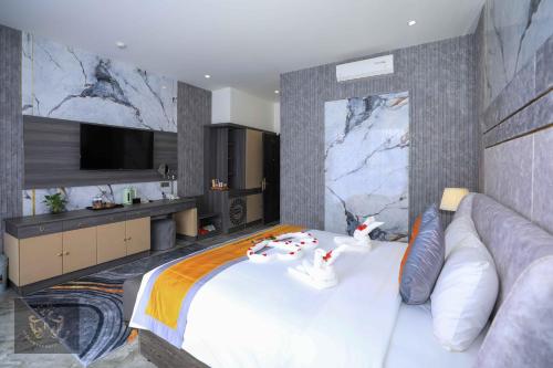 a bedroom with a large white bed and a television at Premium CGP Hotel Hoi An in Hoi An