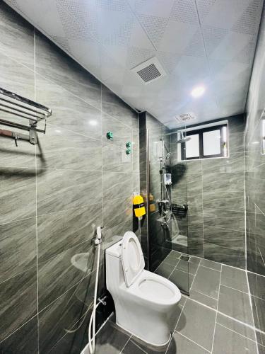 a bathroom with a toilet and a shower at Tịnh Garden Homestay in Yên Ha