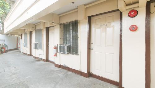a row of white doors on the side of a building at RedDoorz at City Stay Inns Marilao in Lias