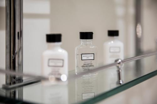 three bottles of moisturizers sit on a glass shelf in a bathroom at Hollywood Hotel in Los Angeles