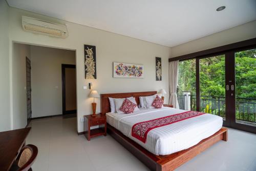 a bedroom with a large bed and a balcony at Mardika Private Villa Ubud in Ubud