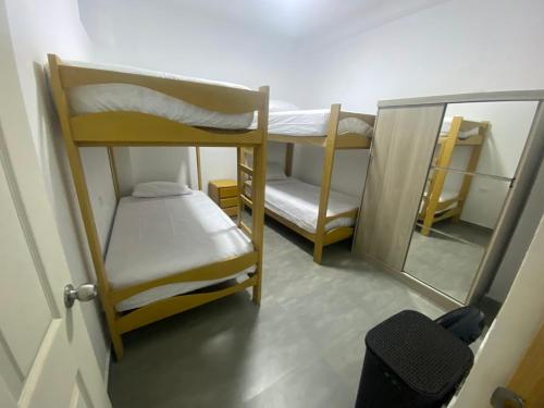 a small room with two bunk beds and a mirror at Departamento Sol y Mar in Caleta Grau