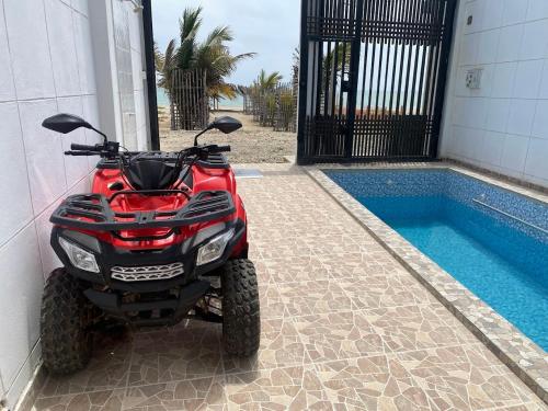 a red atv parked next to a swimming pool at Departamento Sol y Mar in Caleta Grau