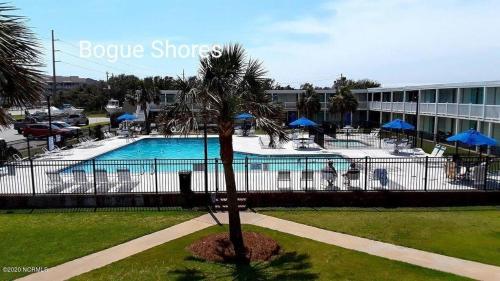 大西洋滩BS266 - 3-min walk to the beach, great pool, dock的棕榈树和建筑的游泳池