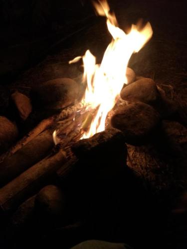 a fire is burning in a fireplace with rocks at Departamento Sol y Mar in Caleta Grau