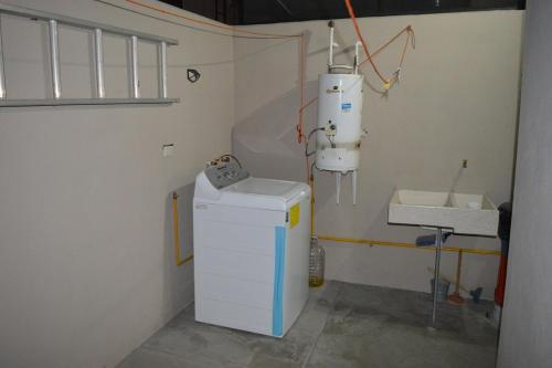 een badkamer met een wasmachine en een wastafel in een kamer bij Casa Lulu junto a Queretaro in Villa Apaseo
