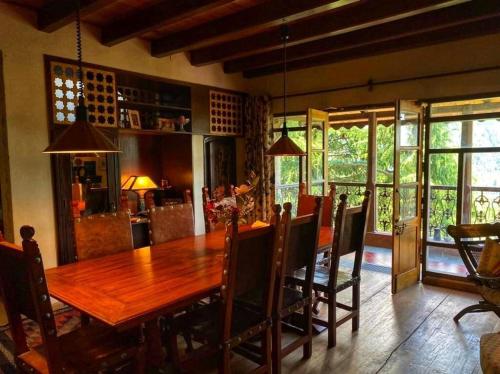 ein Esszimmer mit einem Holztisch und Stühlen in der Unterkunft Mountain View 3bhk Near Mall Road Deodar Retreat in Dalhousie