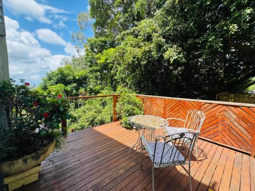 a patio with a table and chairs on a wooden deck at Misty Valley Cottage in Mapleton