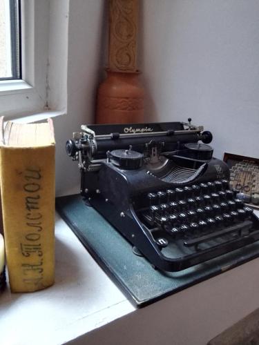 a black typewriter sitting on a desk next to a window at Lea Guest House in Tbilisi City