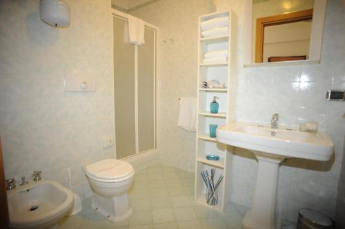 Un baño blanco con inodoro y lavabo. en Lux Appartamenti, en Roma